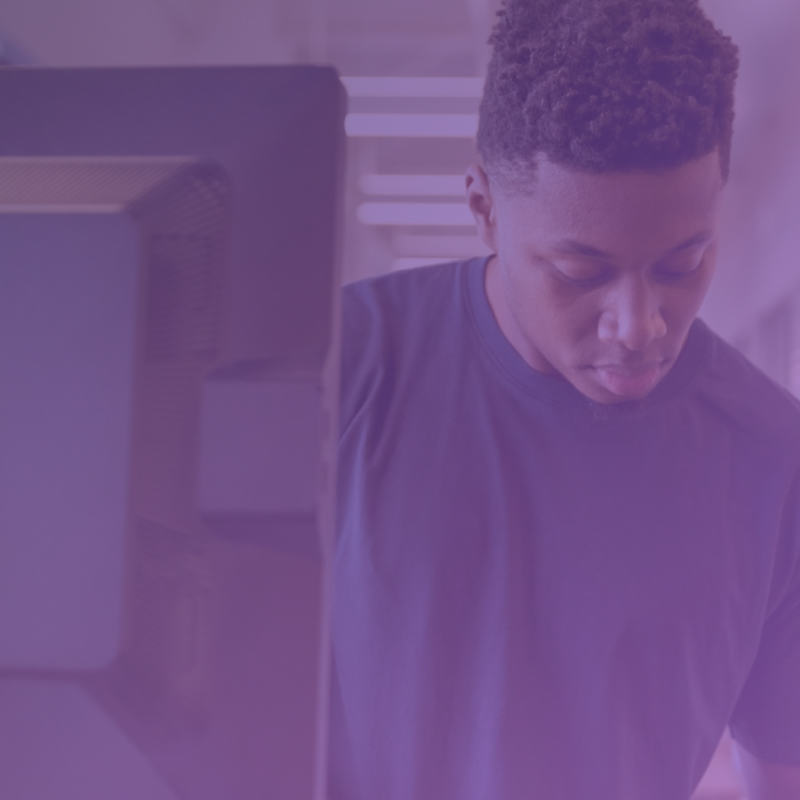 An individual sits at a computer, navigating through screens with ease, symbolizing the streamlined workflow of CISOs and IT managers in simplified compliance management.