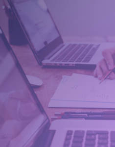 A focused individual conducting a security audit, meticulously reviewing information on a computer screen and taking detailed notes. This image captures the diligence and thoroughness involved in assessing and enhancing cybersecurity measures.